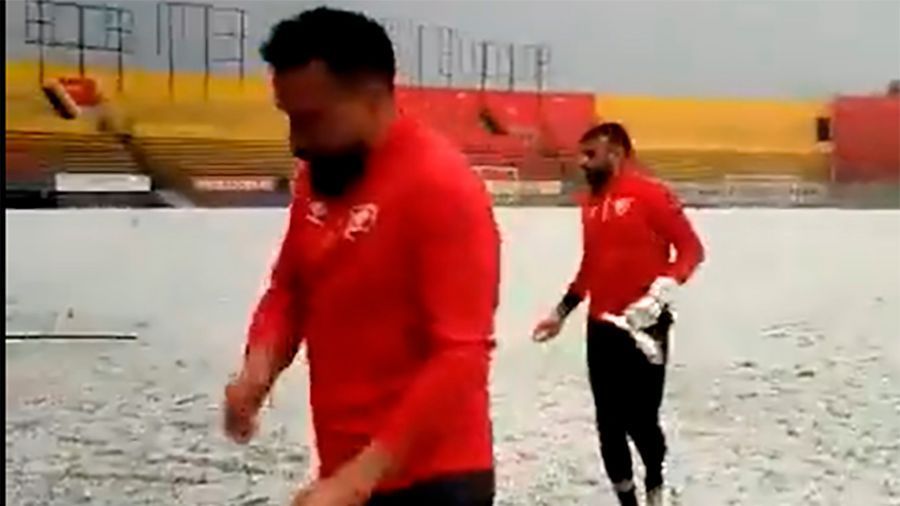 Aucas soccer players have fun with hailstones.