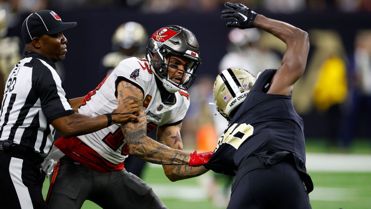 Tampa Bay Buccaneers running back Leonard Fournette (left) shoves