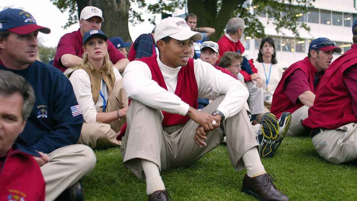 Tiger Woods relajado en rojo y blanco con los espectadores.